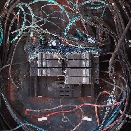 A damaged and burnt fuse box that has broken down.