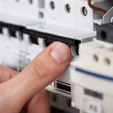 Electrician turning a fuse switch on or off.