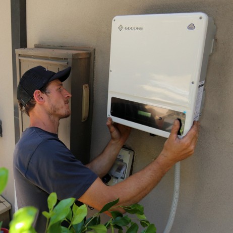 Cameron of HDC Electrical and Solar installing an inverter.