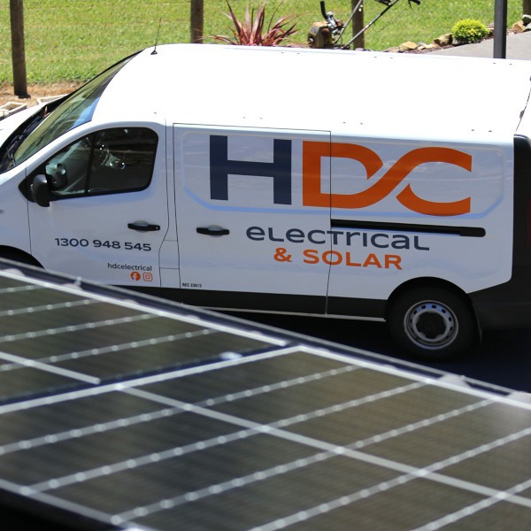 HDC branded van beneath solar panels on a roof.