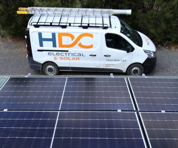 HDC Electrical and Solar van beneath a roof with solar.