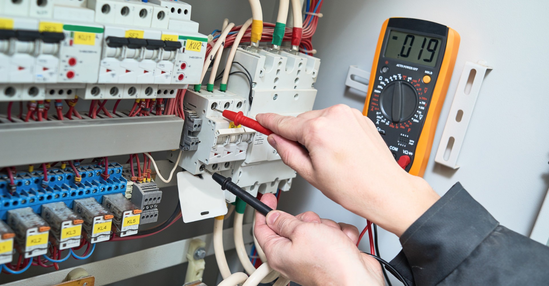 Industrial electrician service of testing with a multimeter.