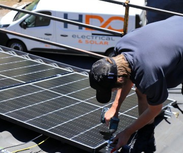 HDC Electrical and Solar staff installing a solar panel.